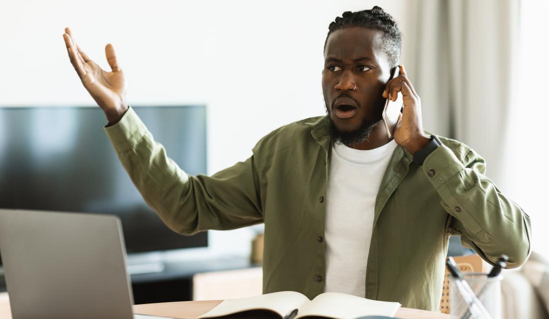 Schmuckbild: Mann vor Laptop, der aufgebracht telefoniert