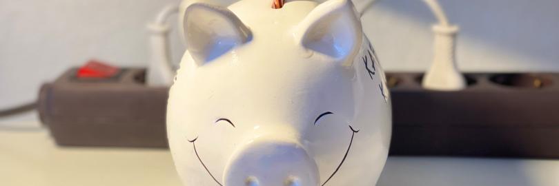 Sparschwein mit einer steckdose im Hintergrund