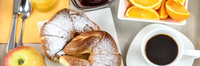 ein Frühstücksgedeck, kaffee orangenecken, marmelade, butterhörnchen