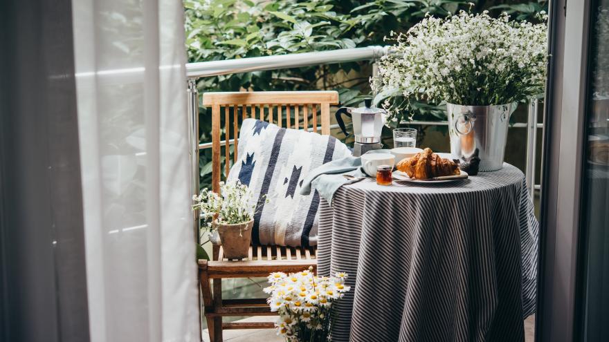 Gemütlicher Balkon mit Pflanzen und Kissen