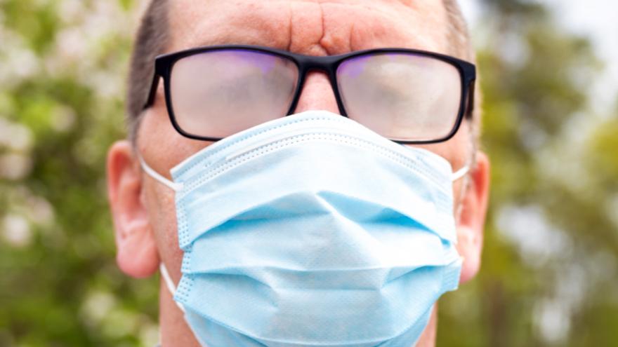 Mann mit Mund-Nasen-Bedeckung und beschlagener Brille