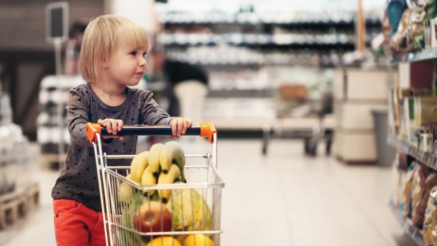 Kita Kind mit Einkaufswagen Obst