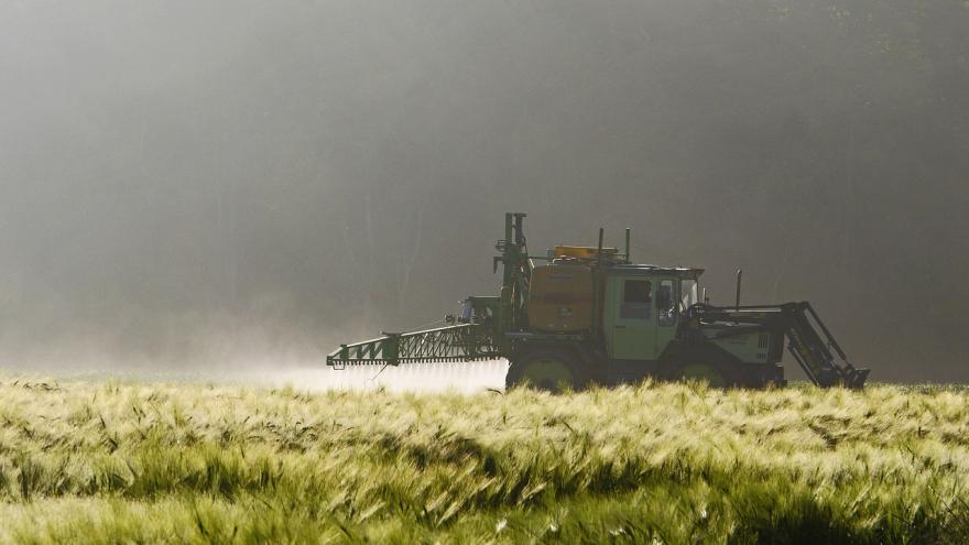 Ein Bauer sprüht mit einem Fahrzeug Pestizide aufs Feld