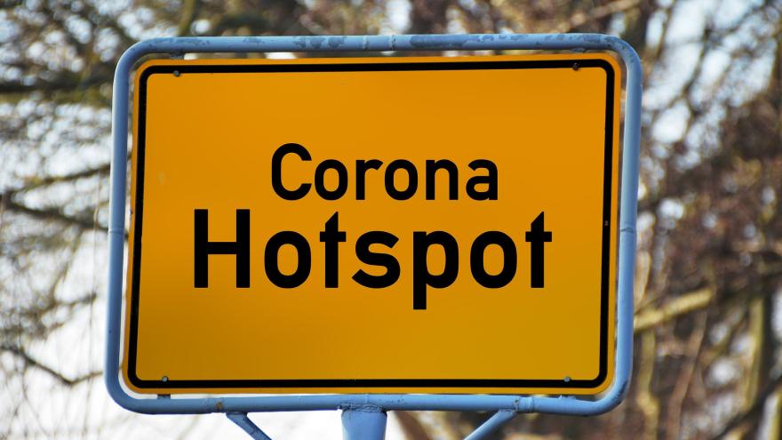 Ortschild mit der Aufschrift "Corona Hotspot"