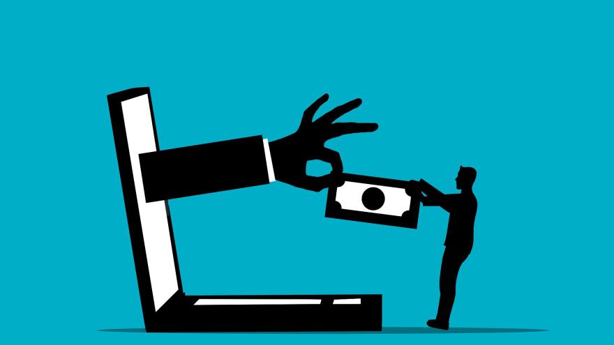 Hand zieht Geld in den Laptop