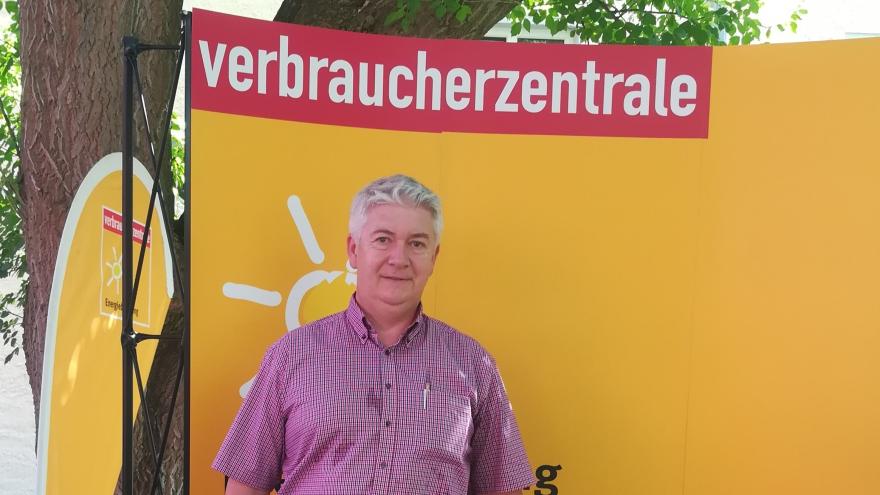 ein mann vor dem Plakat der Verbraucherzentrale