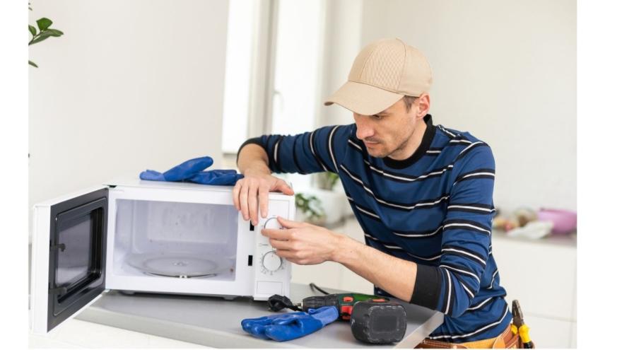 Mann repariert eine Mikrowelle