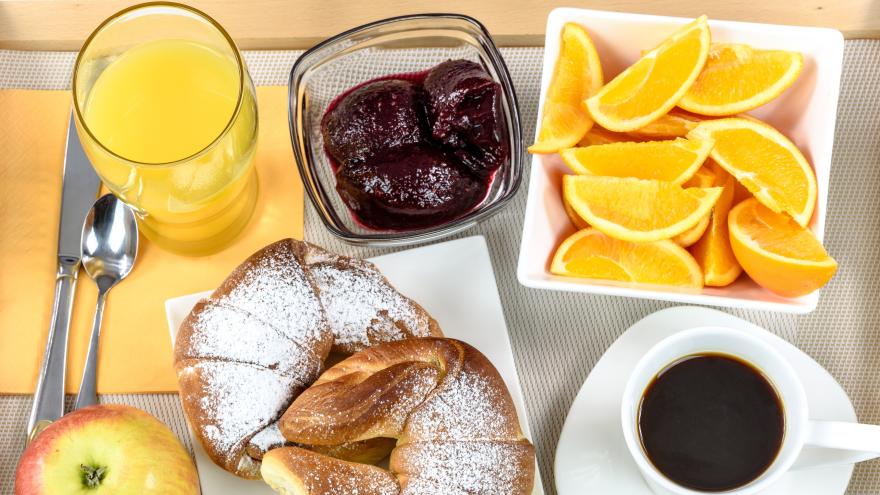 ein Frühstücksgedeck, kaffee orangenecken, marmelade, butterhörnchen
