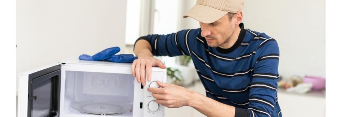 Mann repariert eine Mikrowelle