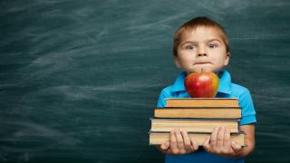 Schulkind mit Apfel und Büchern