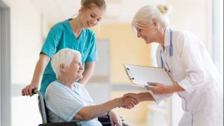 Schmuckbild: Ältere Dame im Rollstuhl wird von Ärztin in Übergangspflege entlassen