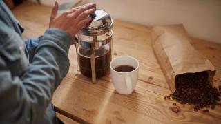 Jemand bereitet Kaffee in einer French Press zu