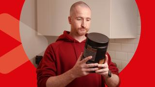 Mann hält Proteinpulver in der Hand