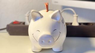 Sparschwein mit einer steckdose im Hintergrund