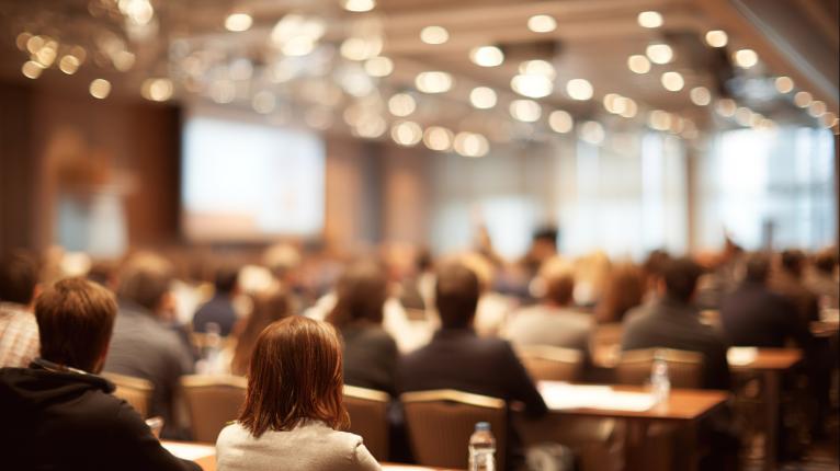 Ein voller Saal mit Publikum bei einem Vortrag